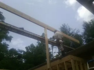 Carpenter setting a ridge beam over a new addition frame — Ice Dam Removal by Roofing Brothers in Jasonville