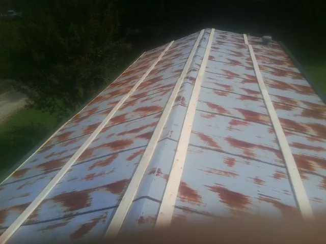 Rusted metal roof panels with new wood purlins before replacement — Storm Damage Roof Repair in Jasonville by Roofing Brothers