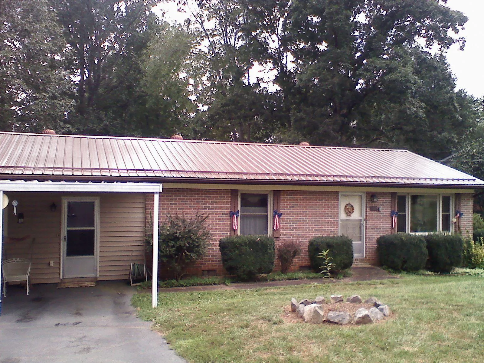 Bronze metal roof and carport on a brick ranch home — Roof Repair work by our crew in Jasonville